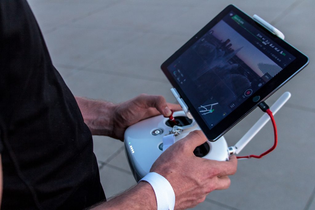 man holding drone remote with tablet app for flying drones on a drone higher job